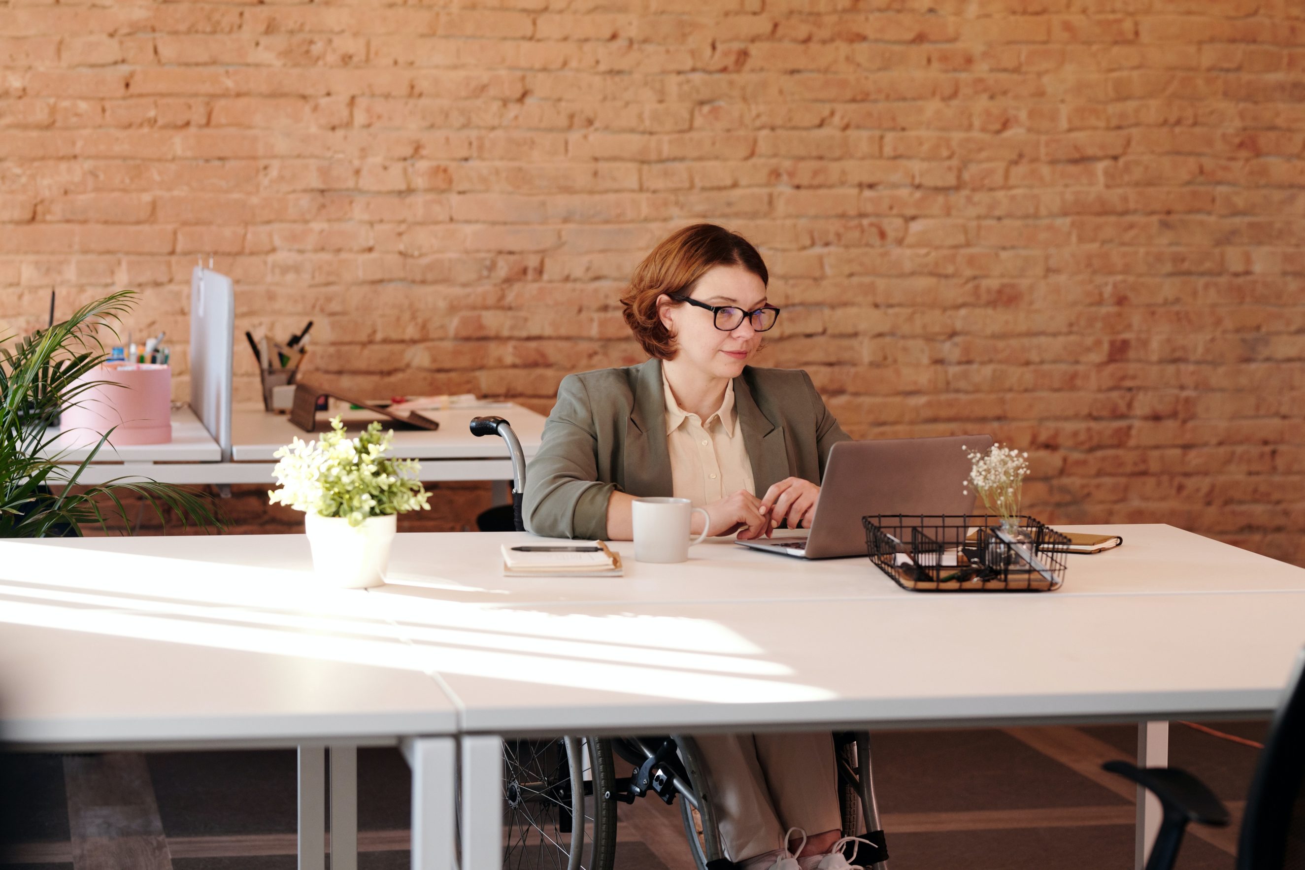 woman sitting at desk in front of brick wall end of year marketing ideas