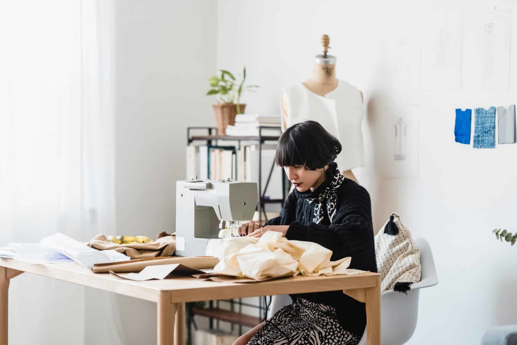 woman sewing at table business success