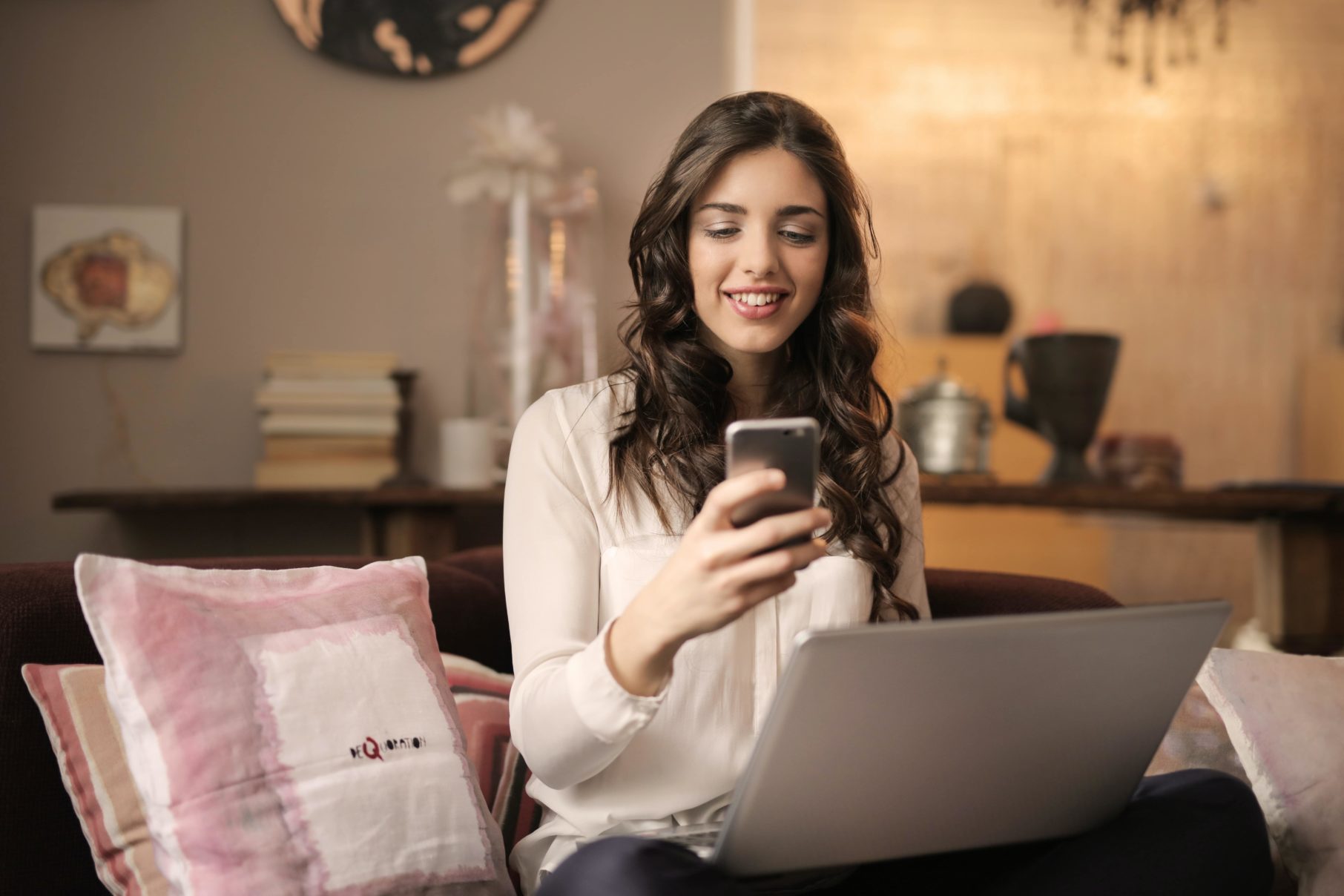 woman using phone and laptop